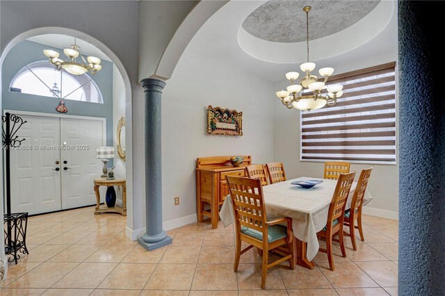 dining space featuring a chandelier, ornate columns, light tile patterned floors, and a raised ceiling