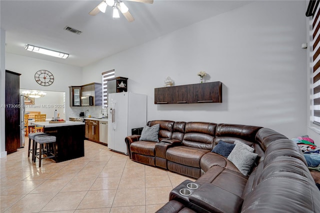 tiled living room featuring ceiling fan with notable chandelier