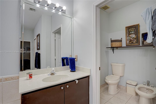 bathroom with vanity, a bidet, toilet, and tile patterned flooring