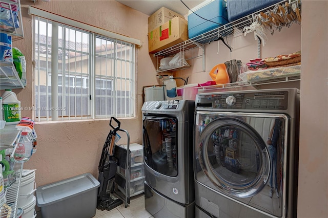 washroom featuring light tile patterned flooring and washer and clothes dryer