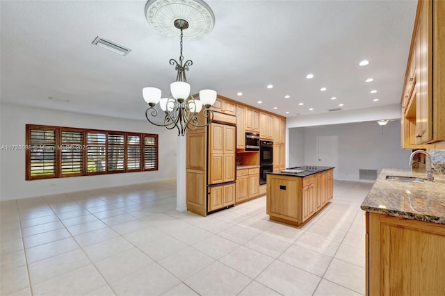 kitchen featuring dark stone countertops, a center island, dobule oven black, visible vents, and a sink
