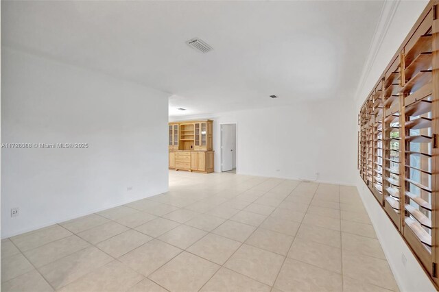 spare room featuring light tile patterned floors and visible vents