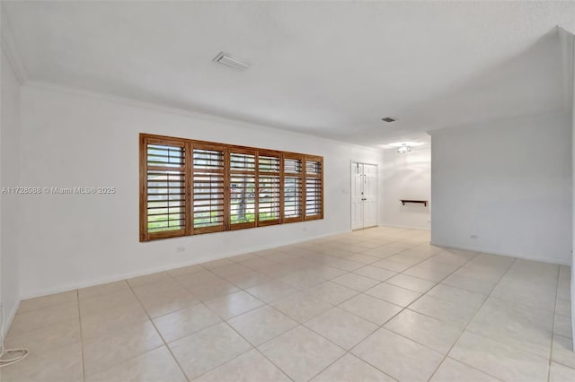 unfurnished room featuring ornamental molding, light tile patterned floors, baseboards, and visible vents