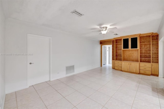 empty room with light tile patterned flooring, ceiling fan, and visible vents