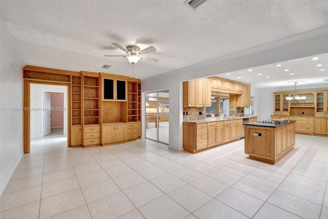 kitchen with glass insert cabinets, a kitchen island, visible vents, ceiling fan with notable chandelier, and a sink