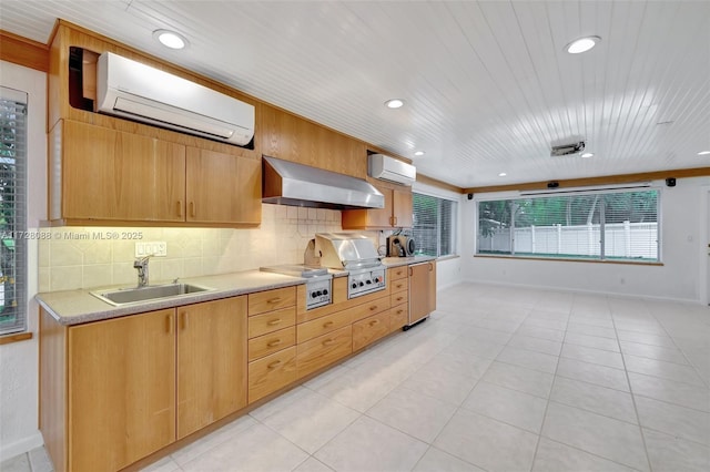 kitchen with a sink, tasteful backsplash, a wall mounted AC, and wall chimney exhaust hood