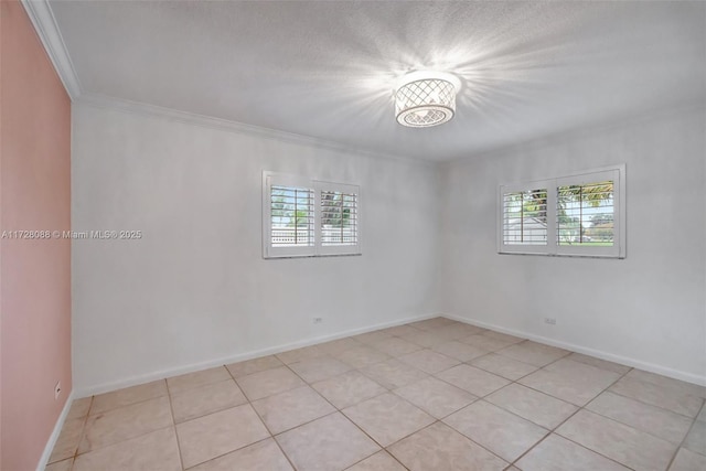 spare room with plenty of natural light, light tile patterned floors, baseboards, and crown molding