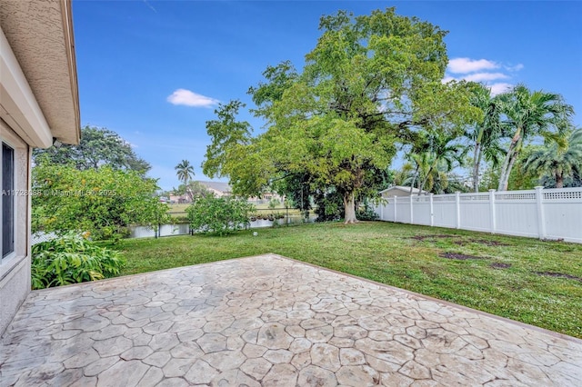 view of patio featuring a fenced backyard and a water view