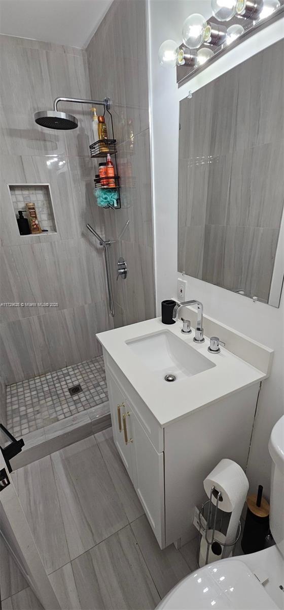 bathroom with toilet, walk in shower, and vanity