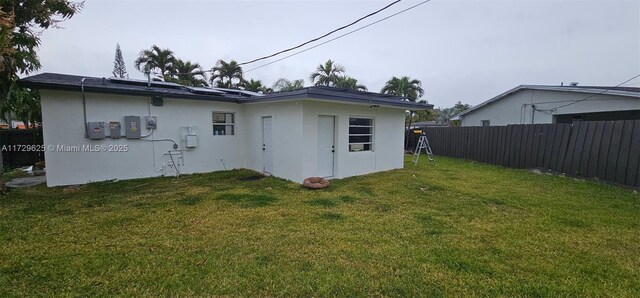 rear view of house featuring a lawn