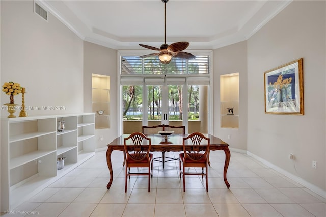 tiled dining space with built in shelves, ornamental molding, ceiling fan, and french doors