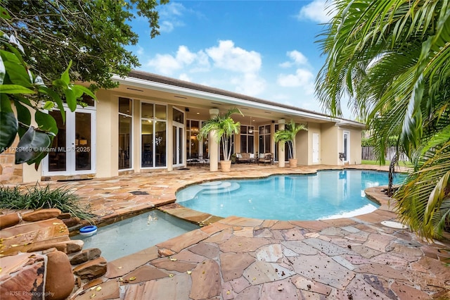 view of swimming pool with a jacuzzi, a patio, and french doors