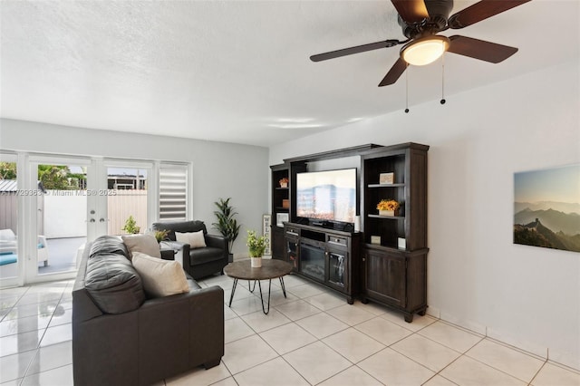 tiled living room featuring ceiling fan, a textured ceiling, and french doors