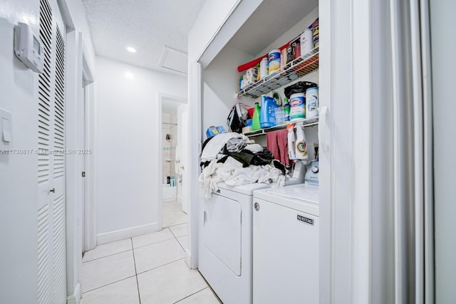 laundry room with light tile patterned flooring, separate washer and dryer, and a textured ceiling