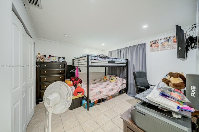 bedroom with ornamental molding and light tile patterned floors