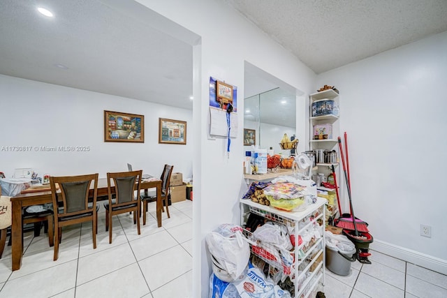 dining space featuring light tile patterned floors and a textured ceiling