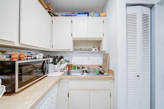 kitchen featuring sink, white cabinetry, and a textured ceiling