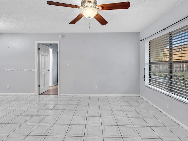 empty room with ceiling fan and a textured ceiling