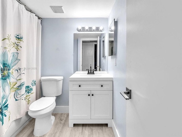 full bathroom with shower / bath combo with shower curtain, hardwood / wood-style floors, toilet, and vanity