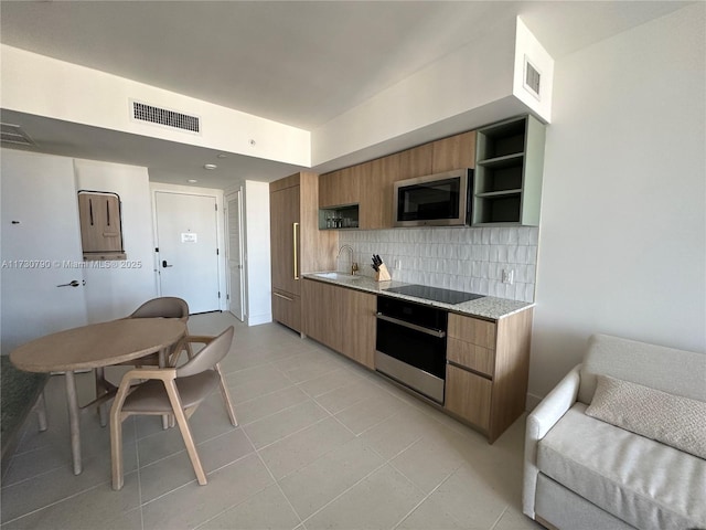 kitchen with sink, light tile patterned floors, tasteful backsplash, black electric stovetop, and oven