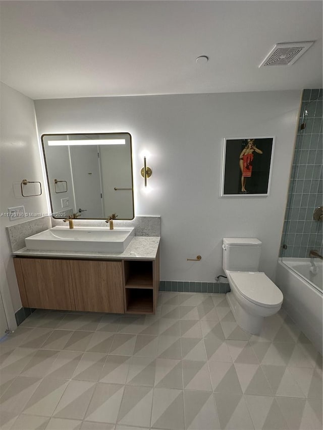 full bathroom featuring tiled shower / bath combo, vanity, and toilet