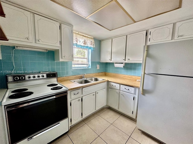 kitchen with sink, white appliances, and white cabinets