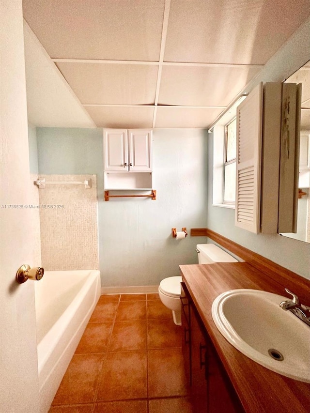 bathroom with toilet, vanity, and tile patterned flooring