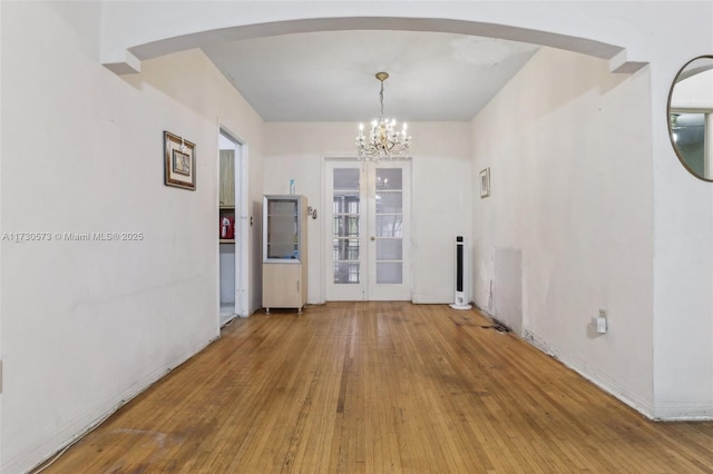 unfurnished dining area featuring hardwood / wood-style flooring and a notable chandelier