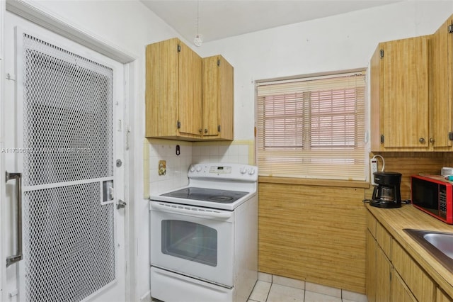 kitchen featuring white range with electric cooktop, sink, decorative backsplash, and light tile patterned floors