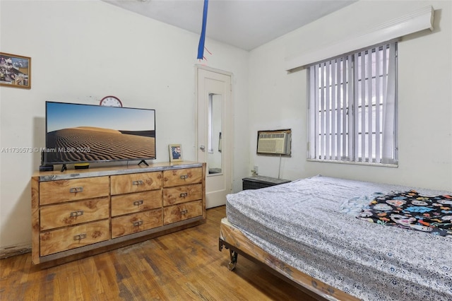 bedroom featuring dark hardwood / wood-style flooring and a wall mounted AC