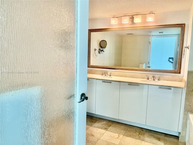 bathroom featuring vanity, a textured ceiling, and a shower with door