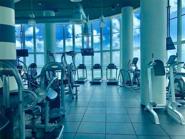 exercise room with a high ceiling and floor to ceiling windows