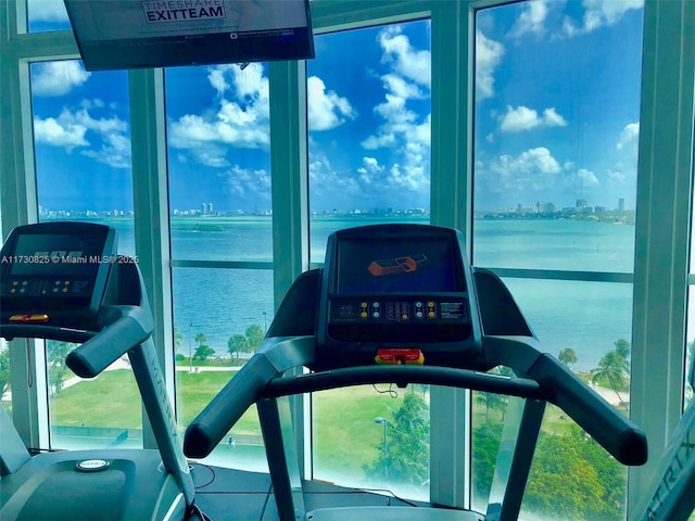 exercise room featuring a water view