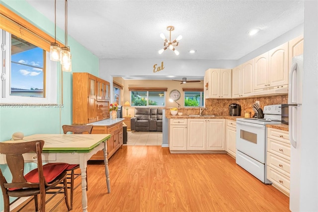 kitchen featuring white appliances, a textured ceiling, decorative light fixtures, tasteful backsplash, and light hardwood / wood-style flooring