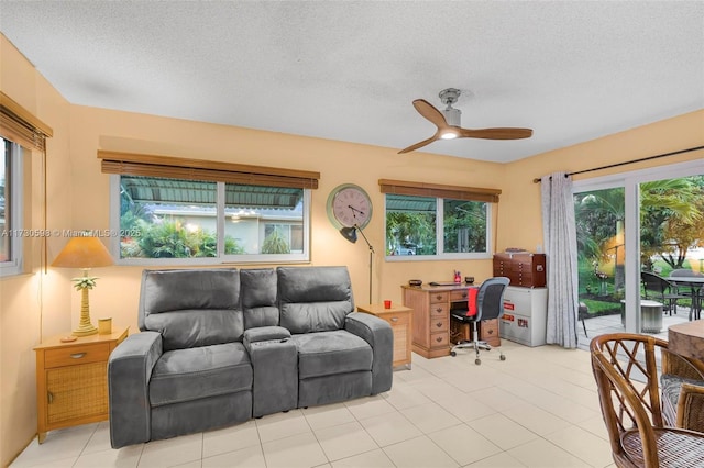 tiled living room featuring ceiling fan and a textured ceiling