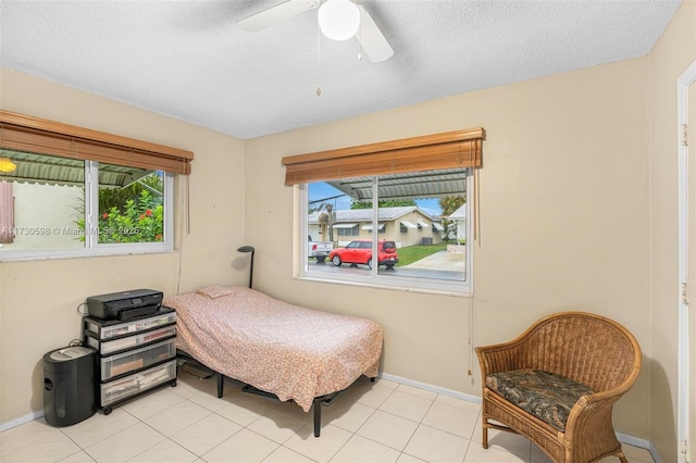 bedroom with a textured ceiling, light tile patterned floors, and ceiling fan