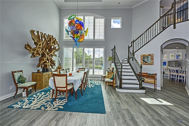 dining space with a high ceiling, hardwood / wood-style floors, and crown molding