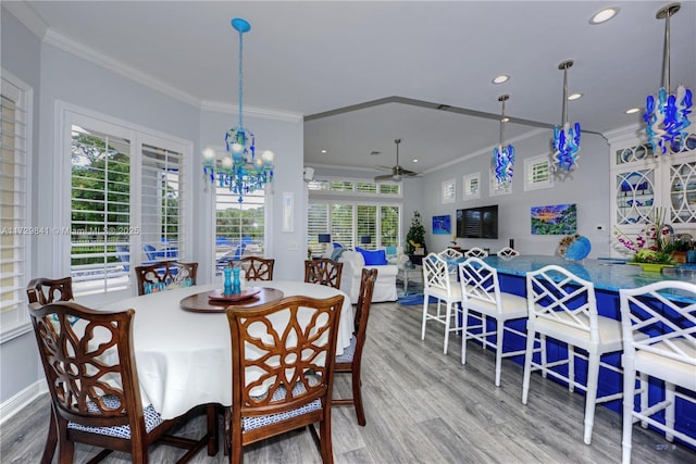 dining room with hardwood / wood-style flooring, plenty of natural light, and crown molding