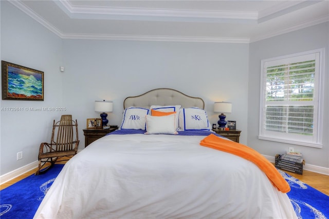 bedroom with a raised ceiling, ornamental molding, and wood-type flooring