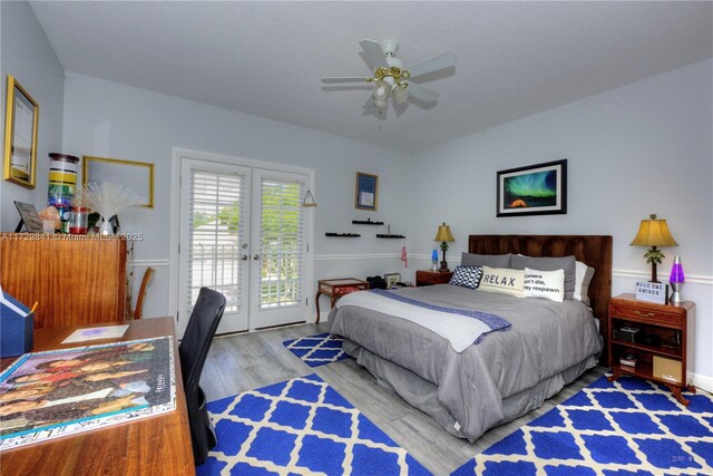 bedroom featuring ceiling fan, hardwood / wood-style floors, access to outside, and french doors