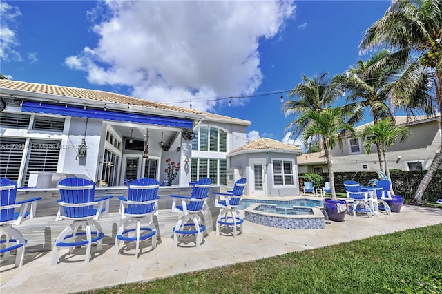 back of property featuring an in ground hot tub, a patio, an outbuilding, and ceiling fan