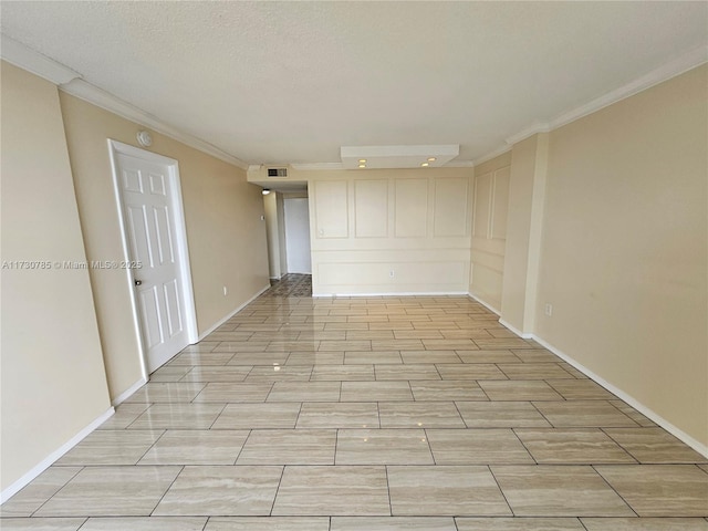 spare room featuring crown molding and a textured ceiling