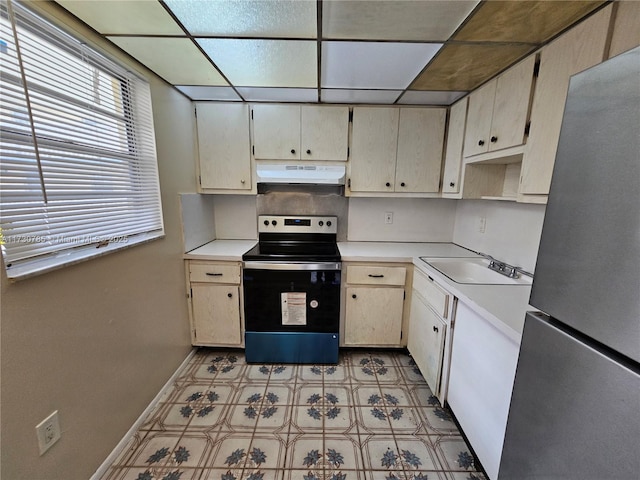 kitchen featuring sink, cream cabinets, stainless steel fridge, and range with electric cooktop