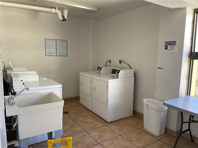 washroom featuring washer and dryer, sink, and light tile patterned floors