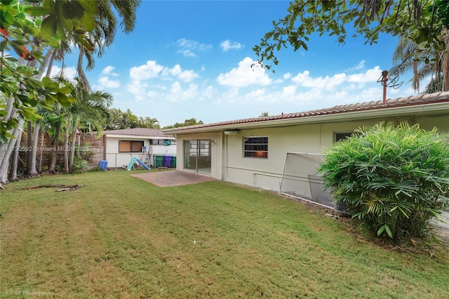 rear view of house with a yard and a patio area