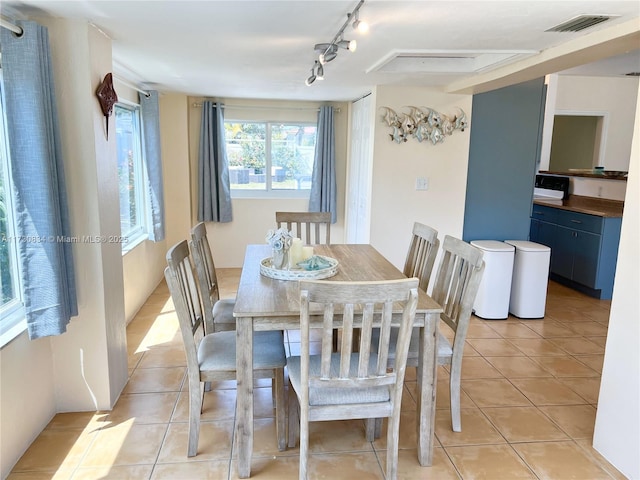 tiled dining area featuring track lighting