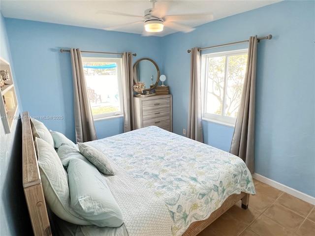 bedroom with multiple windows, light tile patterned floors, and ceiling fan