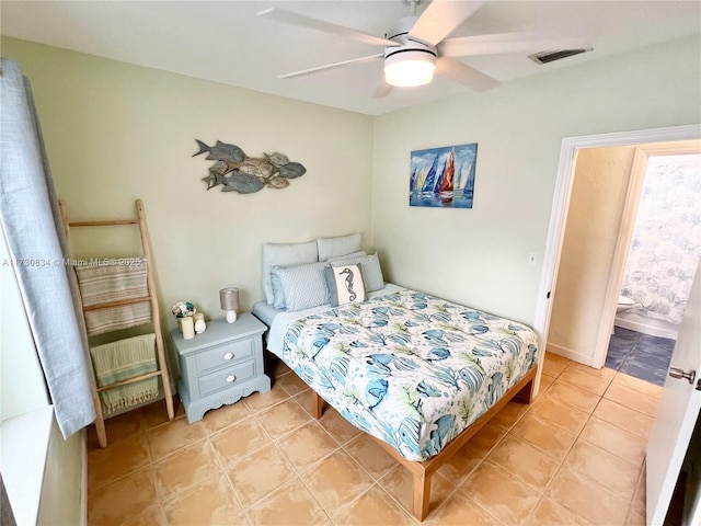 tiled bedroom with ceiling fan and ensuite bathroom