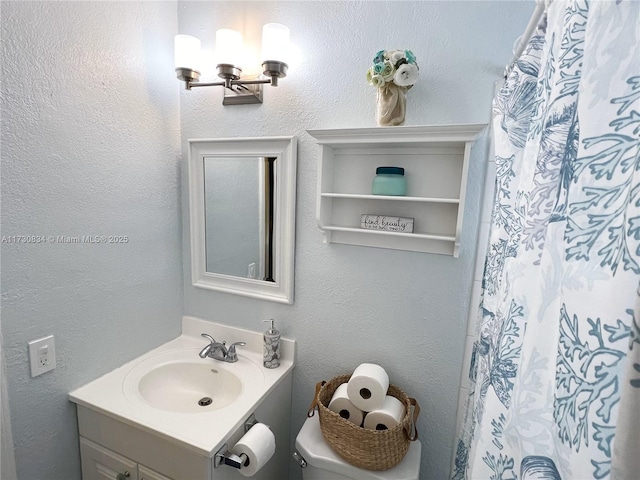 bathroom featuring a shower with curtain, vanity, and toilet