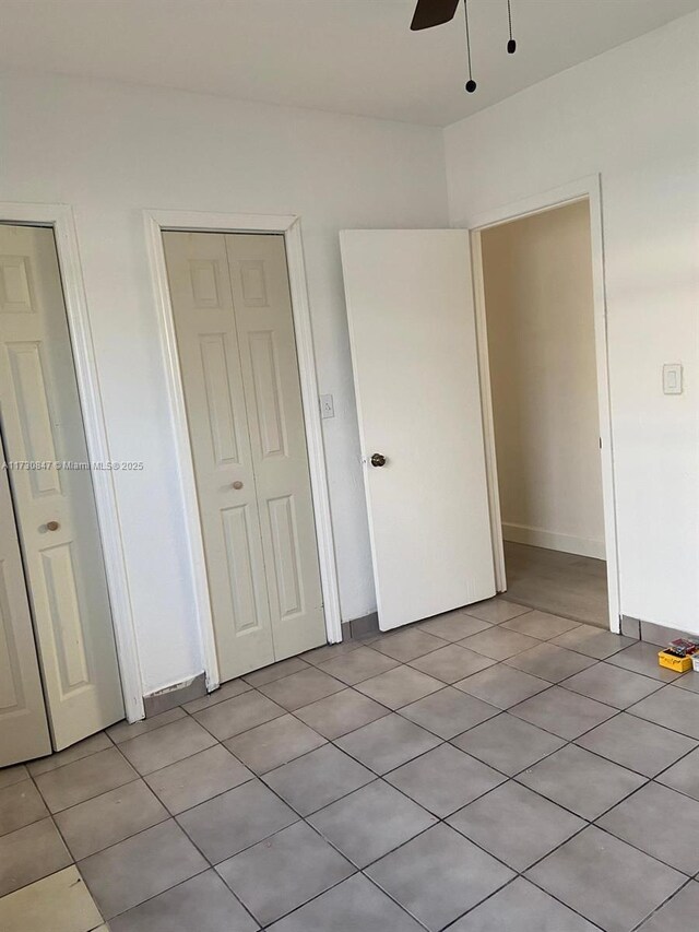 unfurnished bedroom with light tile patterned floors and ceiling fan